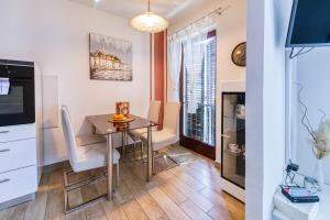 a kitchen and dining room with a table and chairs at Apartman Doris in Lovran