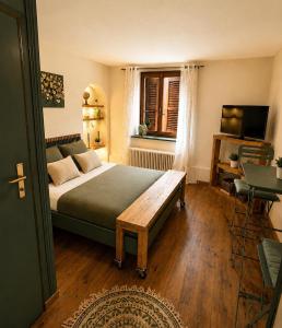 a bedroom with a bed and a table and a window at Hôtel de la Couronne in Les Bois