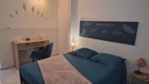 a bedroom with a blue bed with a desk and a desk at 2-3 personnes - Vue Mer et Piscine - Anse à l Âne - trois Îlets - Plage 2 min en voiture in Les Trois-Îlets +20 photos