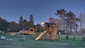 a playground with a slide in a field at SP camping Spāres Prieduļi in Nīca