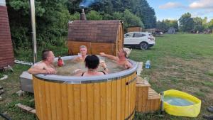 a group of people sitting in a hot tub at SP camping Spāres Prieduļi in Nīca