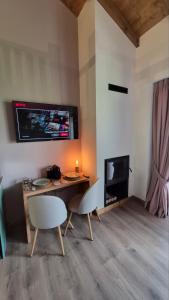 a living room with a table and chairs and a television at Stone Loft Suite in Karpenisi