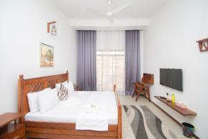 a living room with a bed and a television at Mnazi Dream House in Kiwengwa