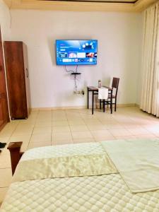 a bedroom with a bed and a tv on the wall at Gravity Villa Musanze in Ruhengeri +6 photos