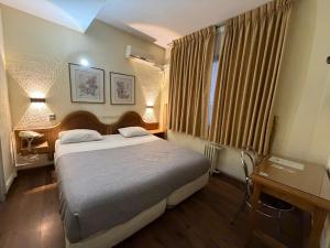 a bedroom with a bed and a window with curtains at Intimo Hotel Miraflores in Santiago
