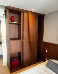 a bedroom with a wooden closet with a bed at Apto em Santos - UNIQUE Residence in Santos +30 photos