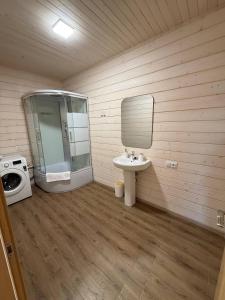 a bathroom with a sink and a glass shower at Тиха Хвиля in Gribovka