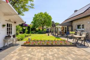 a backyard with a table and chairs and flowers at B&B Cosiness in Balen