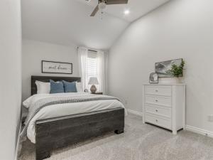 a bedroom with a large bed and a white dresser at Spacious Modern Comfort Fabulous 15th! in Moore