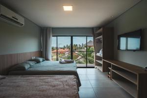 a bedroom with two beds and a flat screen tv at Villas BobZ in Barrinha +50 photos