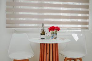 a table with a bottle of wine and two chairs at LV Luxury Apartment in Parga