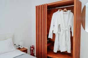 a white robe is hanging in a wooden closet at LV Luxury Apartment in Parga