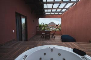 a bath tub in a room with a large window at Villas BobZ in Barrinha