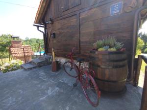 a red bike parked next to a wooden building at Slavotova hiža in Mračin