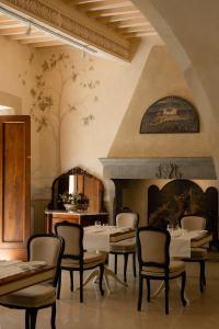 a dining room with tables and chairs and a fireplace at Villa di Piazzano - Small Luxury Hotels of the World in Cortona +117 photos