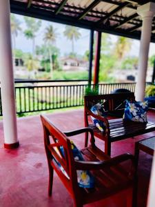 two benches sitting on a porch with a table at S & B Villa Weligama in Weligama