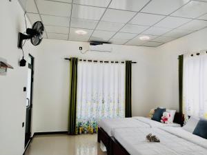 a bedroom with a large bed and curtains at S & B Villa Weligama in Weligama