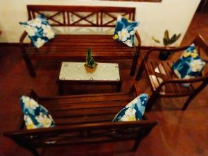 a wooden bench with a table and chairs with pillows at S & B Villa Weligama in Weligama +21 photos