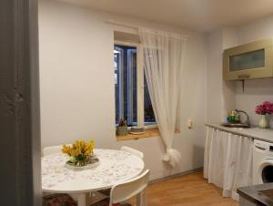 a kitchen with a table with a vase of flowers on it at Saulespuķe-Kuldīgā in Kuldīga