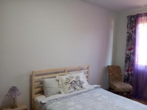 a bedroom with a bed and a chair and a window at Saulespuķe-Kuldīgā in Kuldīga +12 photos