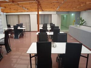 an empty classroom with tables and chairs and a greenboard at Apart Hotel Astore in Antofagasta