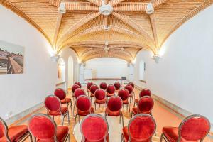 a room with red chairs in a building at HI Évora – Pousada de Juventude in Évora