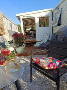 a patio with a chair and a table and a deck at Le Deauville in Le Grau-dʼAgde