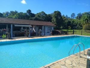 a large swimming pool in front of a house at sitio Ibiúna in Ibiúna