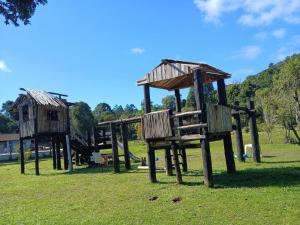 two wooden play structures in a grass field at sitio Ibiúna in Ibiúna