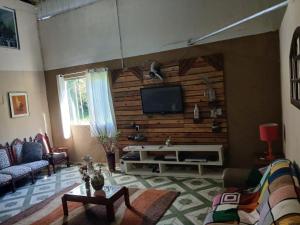 a living room with a flat screen tv on a wall at sitio Ibiúna in Ibiúna