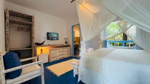 a bedroom with a white bed and a window at Pousada Caraíva in Caraíva +58 photos