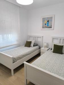 two beds in a room with white walls at Casa Torrox Costa cerca del mar in Torrox