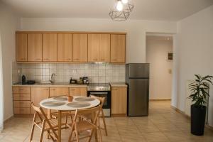 a kitchen with a table and chairs and a refrigerator at Diame Suite - Tzivelekidou in Chrysoupolis +11 photos