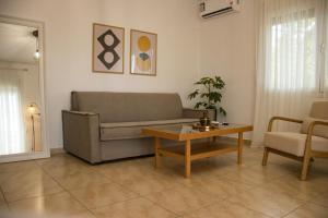 a living room with a couch and a coffee table at Diame Suite - Tzivelekidou in Chrysoupolis