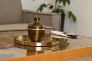 a bronze vase sitting on a table in a living room at Diame Suite - Tzivelekidou in Chrysoupolis