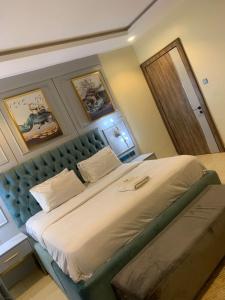 a bedroom with a large bed with a green headboard at Valley in Kado