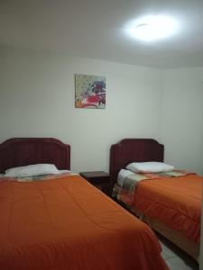 two beds sitting next to each other in a room at Apart Hotel Astore in Antofagasta