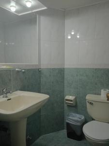 a bathroom with a sink and a toilet and a mirror at Apart Hotel Astore in Antofagasta +13 photos
