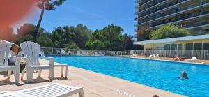 a pool with two chairs and a person in the water at Abbaye de Roseland le Lara chambre double avec roof top vue mer in Nice