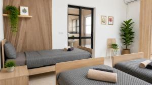 a bedroom with two beds and a mirror at Arzella Apartments Xlendi, Premium 2BR, Bus Stop & Market Opposite in Xlendi