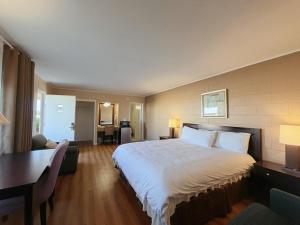 a hotel room with a large bed and a desk at Royal Inn and Suites in Hemet