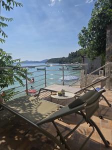 a patio with a table and chairs next to the water at Moreto in Slano