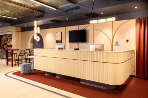 a lobby with a reception desk with a flat screen tv at B&B HOTEL Wrocław Old Town in Wrocław