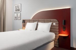 a bedroom with a white bed and a red wall at B&B HOTEL Wrocław Old Town in Wrocław +86 photos
