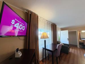 a room with a flat screen tv in a hotel room at Royal Inn and Suites in Hemet +34 photos
