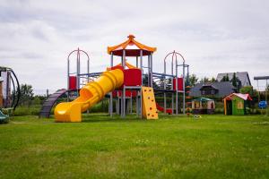 a playground with a slide in a grass field at Apartamenty Lagos in Karwia