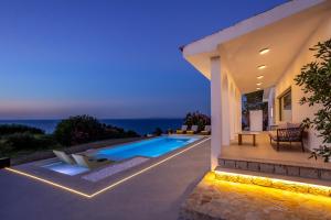 a villa with a swimming pool at night at Xenia Sea view Villa in Argassi