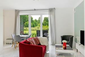 a living room with a red couch and a table at Auszeit in der Heide mit Terrasse in Bienenbüttel