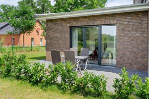 a patio with a table and chairs in front of a building at Auszeit in der Heide mit Terrasse in Bienenbüttel