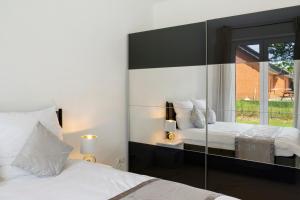 a bedroom with two beds and a large mirror at Auszeit in der Heide mit Terrasse in Bienenbüttel